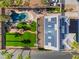 An aerial view of the home showcases a solar-paneled roof, pool, grotto, outdoor seating, and artificial turf at 1407 Fields St, Las Vegas, NV 89142
