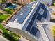 An aerial view of a home with solar panels highlighting the backyard with pool, grotto and artificial turf at 1407 Fields St, Las Vegas, NV 89142