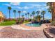 A backyard with a pool, rock features, mature palm trees, and ample space for outdoor enjoyment at 1407 Fields St, Las Vegas, NV 89142