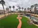 This lush backyard features a large lawn, palm trees, pool, and waterfall; perfect for outdoor living and entertaining at 1407 Fields St, Las Vegas, NV 89142