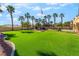 Expansive backyard with lush green lawn, mature palm trees, and a charming water feature at 1407 Fields St, Las Vegas, NV 89142