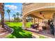 Expansive backyard featuring a covered patio with ample seating and green artificial turf at 1407 Fields St, Las Vegas, NV 89142