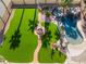 An aerial view shows a backyard with artificial grass, a fire pit, a walk-way, and a pool and spa at 1407 Fields St, Las Vegas, NV 89142