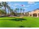 Lush backyard with mature trees, a charming water feature, and well-maintained artificial turf at 1407 Fields St, Las Vegas, NV 89142