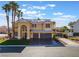 Stunning two-story home featuring a three-car garage, well-manicured lawn, and mature palm trees at 1407 Fields St, Las Vegas, NV 89142