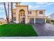 Well-manicured lawn and mature trees enhance the curb appeal of this two-story home at 1407 Fields St, Las Vegas, NV 89142