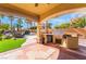 Outdoor kitchen featuring a built-in grill, mini-fridge, and ample counter space, perfect for entertaining at 1407 Fields St, Las Vegas, NV 89142