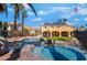 Backyard pool with an attached hot tub and a rock waterfall feature, surrounded by a lush landscaped backyard at 1407 Fields St, Las Vegas, NV 89142