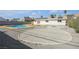 Large backyard with a pool, patio, desert landscaping, and a surrounding fence under a sunny sky at 1616 Yellow Rose St, Las Vegas, NV 89108