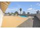 Fenced backyard featuring in-ground pool, concrete patio, and desert landscaping under sunny skies at 1616 Yellow Rose St, Las Vegas, NV 89108