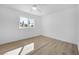 Bedroom with wood-look floors, white walls, ceiling fan, and natural light at 1616 Yellow Rose St, Las Vegas, NV 89108