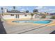 The home's backyard shows a refreshing in-ground pool, patio, desert landscaping, and solar panels at 1616 Yellow Rose St, Las Vegas, NV 89108