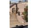 Landscaped backyard with a wooden walkway, decorative plants, and unique desert-style charm at 1826 Dunes Ct, Laughlin, NV 89029
