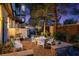 Charming backyard featuring white patio furniture, stone walls, and lush landscaping, creating an inviting outdoor space at 2 Yorkridge Ct, Henderson, NV 89052