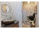 Powder bathroom with stone sink, decorative mirror, textured wallpaper, and modern fixtures at 2 Yorkridge Ct, Henderson, NV 89052