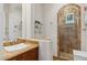 Elegant bathroom featuring a large vessel sink, decorative mirror, tiled shower with glass door, and marble countertops at 2 Yorkridge Ct, Henderson, NV 89052