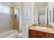 Bathroom featuring a vessel sink, wood cabinets, tiled shower with glass door, and an expansive mirror at 2 Yorkridge Ct, Henderson, NV 89052