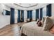 Inviting bedroom with wood floors, tray ceilings, large windows and blue curtains at 2 Yorkridge Ct, Henderson, NV 89052