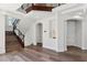 Elegant foyer with hardwood floors, staircase with wrought iron railing, arched doorways, and custom lighting at 2 Yorkridge Ct, Henderson, NV 89052