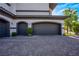 Attached three-car garage with dark gray doors and a brick-paved driveway in front at 2 Yorkridge Ct, Henderson, NV 89052