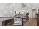 Elegant hallway with iron railing overlooking living area with fireplace and backyard views at 2 Yorkridge Ct, Henderson, NV 89052