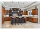Large kitchen featuring wooden cabinets, granite island with stools, and stainless steel appliances at 2 Yorkridge Ct, Henderson, NV 89052