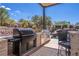 Well-equipped outdoor kitchen with stainless steel appliances and bar seating, perfect for entertaining poolside at 2 Yorkridge Ct, Henderson, NV 89052