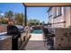 Outdoor kitchen with a bar overlooks the pool and waterfall, creating a perfect space for relaxation and entertainment at 2 Yorkridge Ct, Henderson, NV 89052