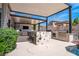 Stylish outdoor kitchen and seating area with overhead cover, great for entertaining beside the sparkling pool at 2 Yorkridge Ct, Henderson, NV 89052