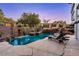 Backyard pool with rock waterfall feature and comfortable lounge chairs for relaxing, creating a backyard oasis at 2 Yorkridge Ct, Henderson, NV 89052