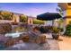 Stunning rock waterfall feature enhances this custom pool with lush garden accents, offering a serene backyard oasis at 2 Yorkridge Ct, Henderson, NV 89052