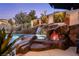 Inviting pool features rock waterfall, fire feature, and vibrant greenery, perfect for relaxation and outdoor enjoyment at 2 Yorkridge Ct, Henderson, NV 89052