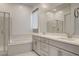 A bathroom featuring a double vanity, soaking tub, and glass-enclosed shower at 21 Reverie Heights Ave, Henderson, NV 89011