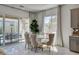 Elegant dining area with a modern white table and chairs, ample natural light, and backyard view at 21 Reverie Heights Ave, Henderson, NV 89011