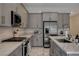 Stylish kitchen with a large island, stainless appliances, gray cabinets, and stone countertops at 21 Reverie Heights Ave, Henderson, NV 89011