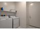 Functional laundry room with washer, dryer, shelf, and access to an exterior door at 21 Reverie Heights Ave, Henderson, NV 89011