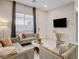 Bright living room featuring tile floors, modern furniture, and a large window for natural light at 21 Reverie Heights Ave, Henderson, NV 89011