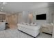 Bright and airy living room with white walls, a large TV, decorative molding and luxurious white marble-like flooring at 21 Reverie Heights Ave, Henderson, NV 89011