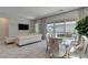 Open concept living and dining area featuring a luxurious white sofa, stylish chairs, and a view of the pool at 21 Reverie Heights Ave, Henderson, NV 89011