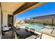 Covered patio with outdoor dining and lounge area overlooking a pristine pool and spa, designed for luxury and comfort at 21 Reverie Heights Ave, Henderson, NV 89011