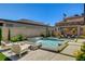 Stunning pool area with waterfall feature, spa, firepit, and covered seating area perfect for outdoor entertaining at 21 Reverie Heights Ave, Henderson, NV 89011
