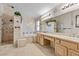 Luxurious bathroom with marble tiling, a soaking tub, a walk-in shower, and a double vanity sink at 2112 Preakness Pass, Las Vegas, NV 89117