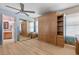 Bright bedroom featuring wood floors, ceiling fan, and built-in wardrobe with mirrored closet, offering ample storage at 2112 Preakness Pass, Las Vegas, NV 89117