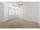 A well-lit bedroom featuring carpeted floors, neutral walls, and a ceiling fan at 2333 Silver Crew Pass, Henderson, NV 89052