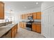 Well-equipped kitchen with wooden cabinets, stainless steel appliances, granite countertops, and tile floors at 2333 Silver Crew Pass, Henderson, NV 89052