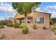 Landscaped backyard with desert landscaping, view of large window and covered patio at 2343 Galilean Moon St, Henderson, NV 89044