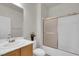 Clean bathroom featuring a shower with glass doors, a white toilet and vanity with wooden cabinets at 2343 Galilean Moon St, Henderson, NV 89044