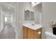 Well-lit bathroom featuring a single sink vanity and a large mirror and with tile floors at 2343 Galilean Moon St, Henderson, NV 89044