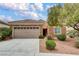 Charming single-story home featuring a two-car garage, stone accents, and a well-maintained front yard with lush landscaping at 2343 Galilean Moon St, Henderson, NV 89044