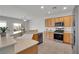 Open-concept kitchen with stainless steel appliances, wood cabinetry, and a breakfast bar, perfect for entertaining at 2343 Galilean Moon St, Henderson, NV 89044